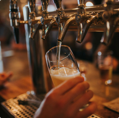 Pouring beer into a glass from a Tap With Frothy Bubbles