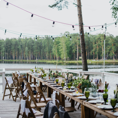 Outdoor Event Setup: Wooden Table and Chairs Arranged Amidst Scenic Nature For Celebration
