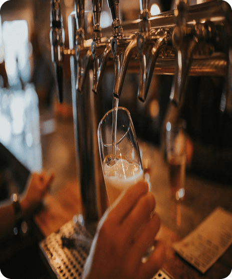 Pouring beer into a glass from a Tap With Frothy Bubbles